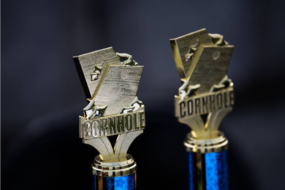Two cornhole trophies sitting next to one another